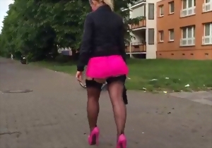 Sweetheart in a pink miniskirt looks good on glossy high heels